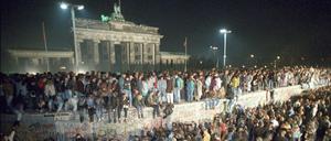 Menschen auf der Berliner Mauer vor dem Brandenburger Tor in der Nacht vom 9. auf den 10.11.1989.