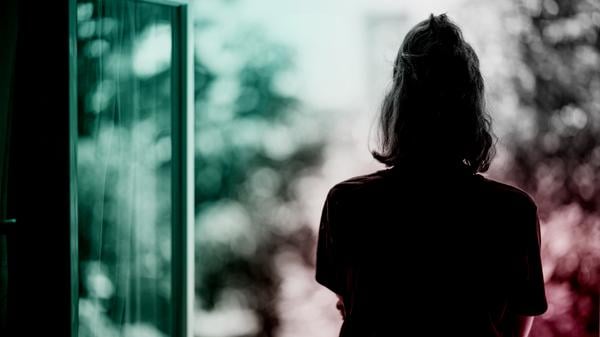 Eine Frau steht am Fenster