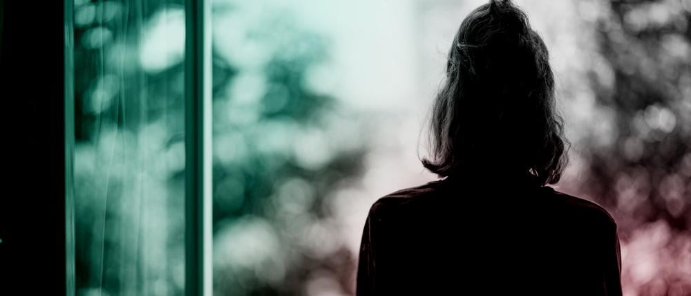 Eine Frau steht am Fenster