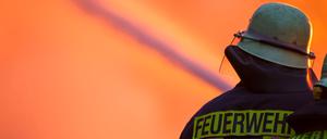 Ein Feuerwehrmann löscht ein großes Feuer.