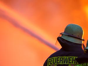 Ein Feuerwehrmann löscht ein großes Feuer.