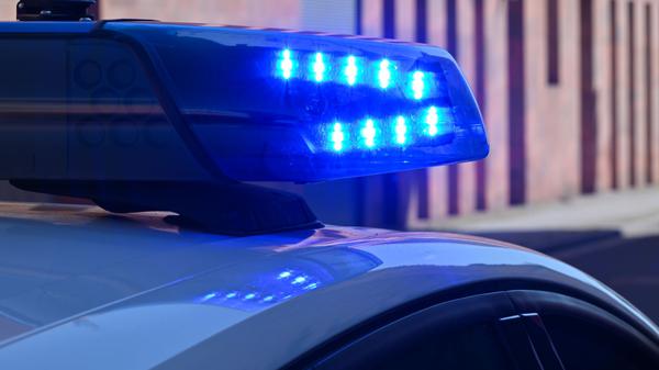 Ein Polizeifahrzeug fährt mit Blaulicht durch die Innenstadt.