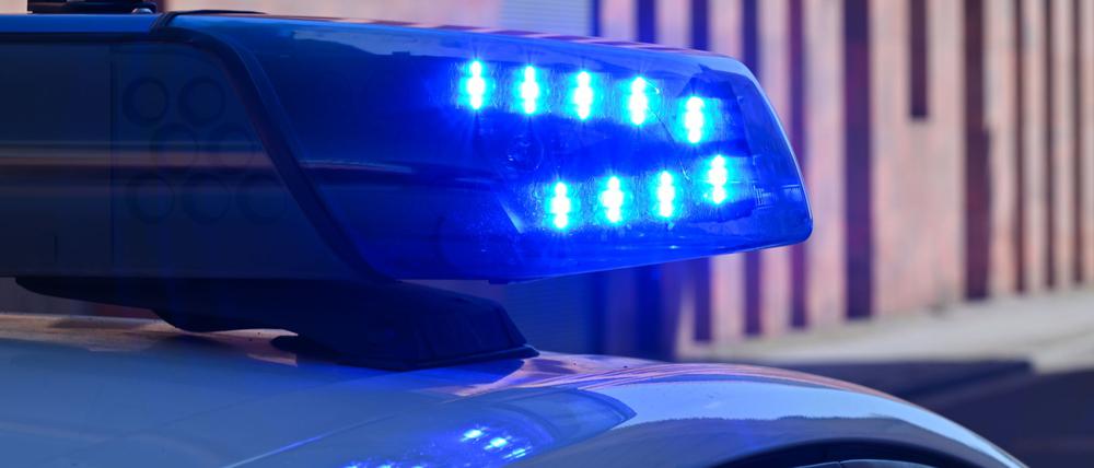 Ein Polizeifahrzeug fährt mit Blaulicht durch die Innenstadt.