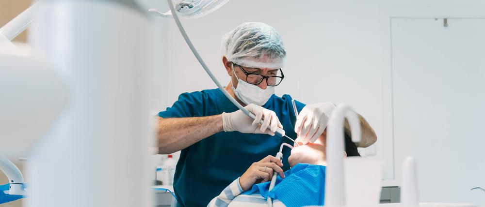 Ein Zahnarzt und vor ihm ein Patient.