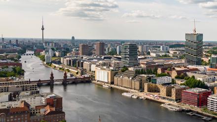 Drohenansicht auf die Berliner Spree mit dem Badeschiff unten, Amazon-Tower rechts und dem Fernsehturm oben.
