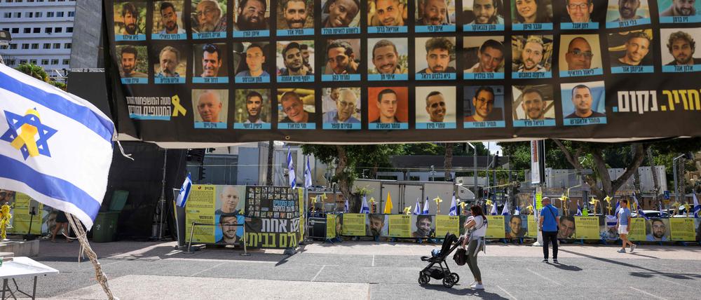 Menschen gehen am 10. Oktober 2025 in Tel Aviv am Hostage Square an Plakaten mit Geiseln vorbei, die von der palästinensischen militanten Gruppe Hamas in Gaza festgehalten werden.