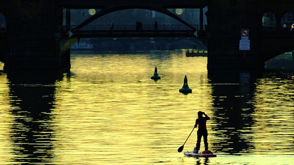 Eine Stehpaddlerin ist am Abend auf der Spree unweit der Oberbaumbrücke unterwegs. +++ dpa-Bildfunk +++