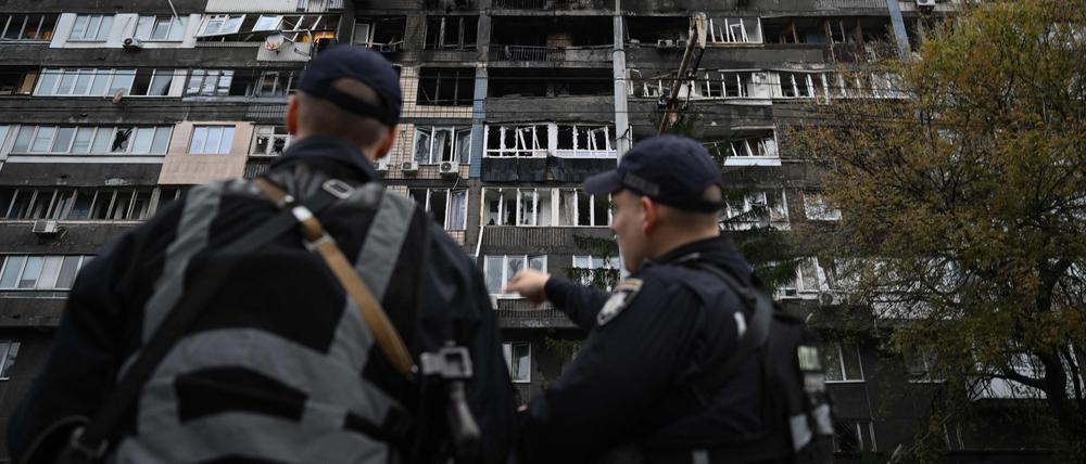 Ukrainische Polizisten stehen vor einem Wohnhaus, das bei massiven russischen Drohnen- und Raketenangriffen auf Kiew am 10. Oktober 2025 beschädigt wurde.