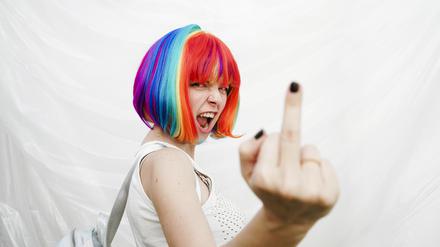 Woman doing obscene gesture in front of plastic backdrop