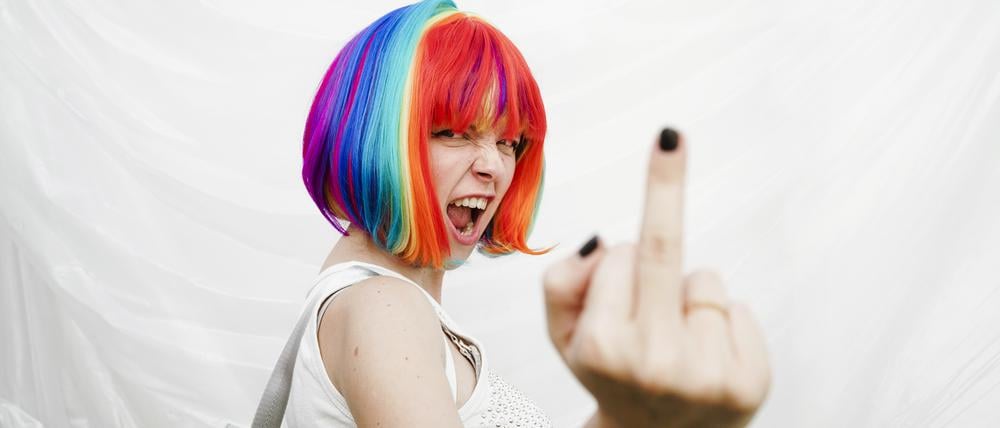 Woman doing obscene gesture in front of plastic backdrop