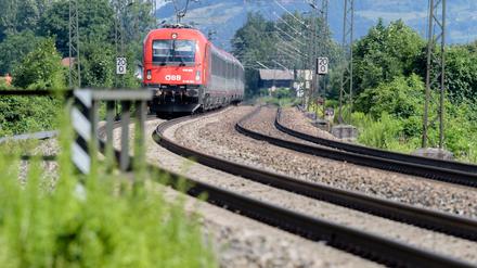 Ein Zug der Österreichischen Bundesbahnen (ÖBB) fährt über die Gleise der Bahntrasse durch das Inntal zwischen Rosenheim und Kufstein. 