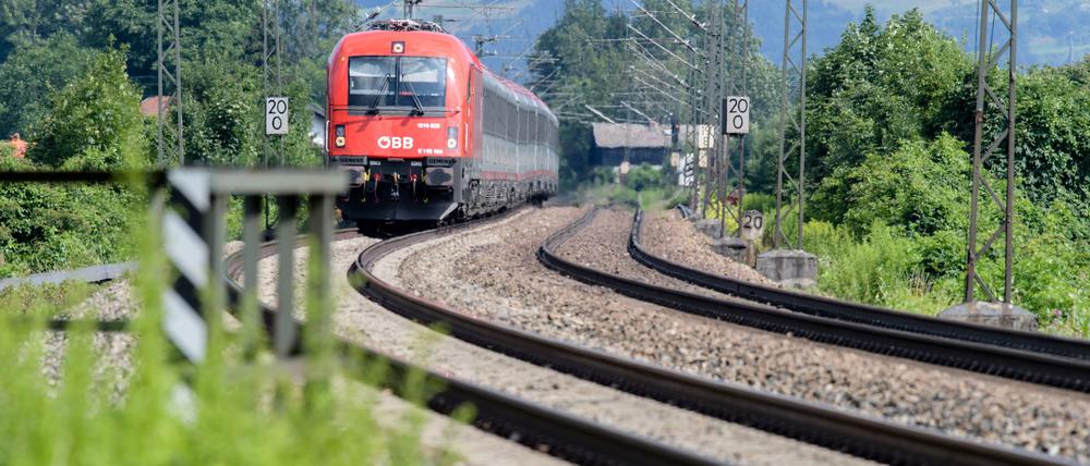 Ein Zug der Österreichischen Bundesbahnen (ÖBB) fährt über die Gleise der Bahntrasse durch das Inntal zwischen Rosenheim und Kufstein.