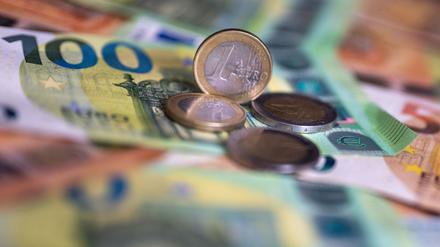 Geldscheine mit dem Wert von 100 und 50 Euro und Münzen liegen auf einem Tisch.