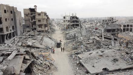 Eine Drohnenaufnahme zeigt Palästinenser, die nach dem Rückzug der israelischen Streitkräfte an Trümmern vorbeigehen.