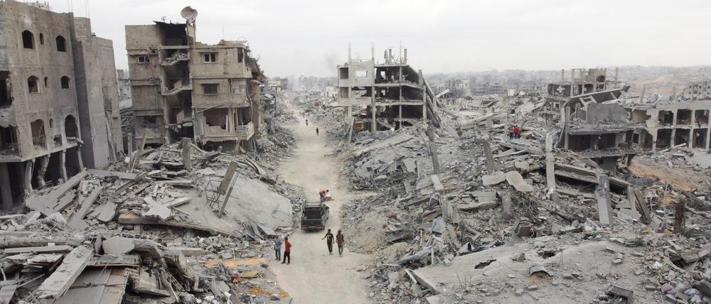 Eine Drohnenaufnahme zeigt Palästinenser, die nach dem Rückzug der israelischen Streitkräfte an Trümmern vorbeigehen.