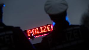 Polizisten stehen im Rahmen eines Fototermins vor einem Polizeifahrzeug (gestellte Szene).