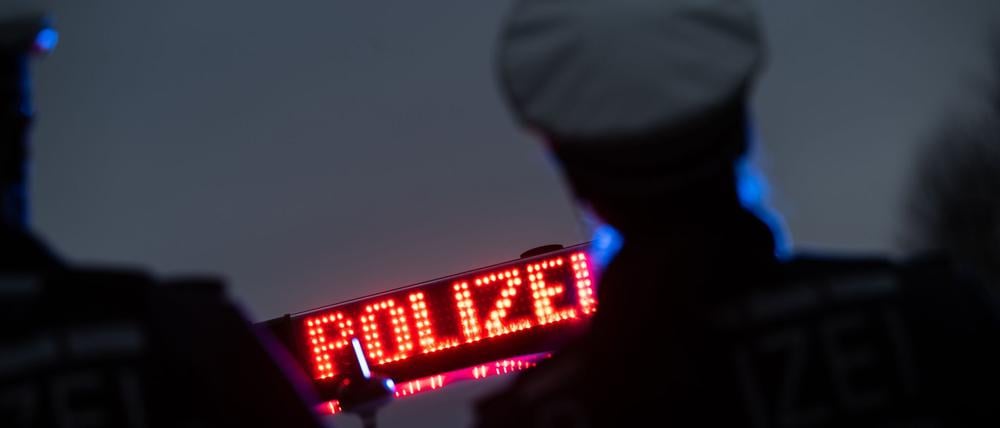 Polizisten stehen im Rahmen eines Fototermins vor einem Polizeifahrzeug (gestellte Szene).
