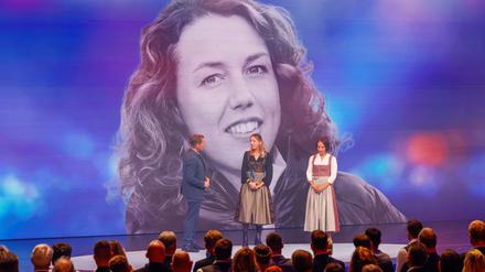 Die Biathletinnen Franziska Preuß und Magdalena Neuner (hier mir Moderator Markus Othmer vor einem Bild von Laura Dahlmeier) haben bei der Verleihung des Bayerischen Sportpreises ihrer gestorbenen Kollegin Dahlmeier gedacht. 