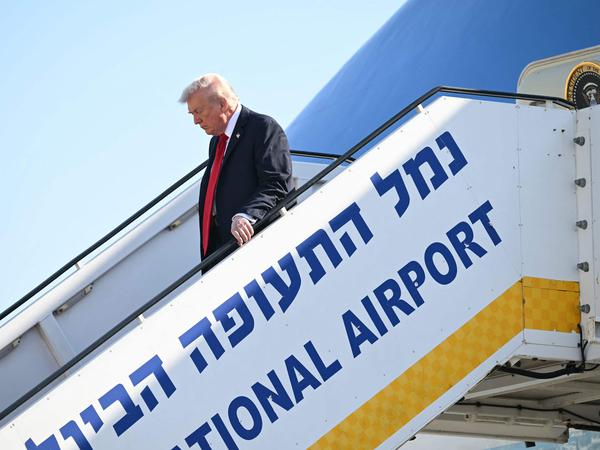 TOPSHOT - US President Donald Trump disembarks from Air Force One upon arrival at Ben Gurion Airport on the outskirts of Lod near Tel Aviv on October 13, 2025, as he travels to Israel and Egypt. Trump is passing through Israel, addressing parliament and meeting with hostage families before heading to Egypt's Sharm El-Sheikh for a major peace summit, where a "document ending the war in the Gaza Strip" is expected to be signed. (Photo by SAUL LOEB / AFP)