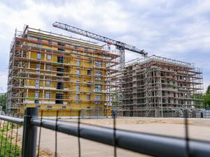 Auf einer Baustelle entstehen Mehrfamilienhäuser mit vielen Wohneinheiten.