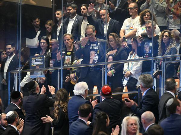 Family members of Israeli hostages acknowledge applause at the Knesset, in Jerusalem on October 13, 2025.    SAUL LOEB/Pool via REUTERS