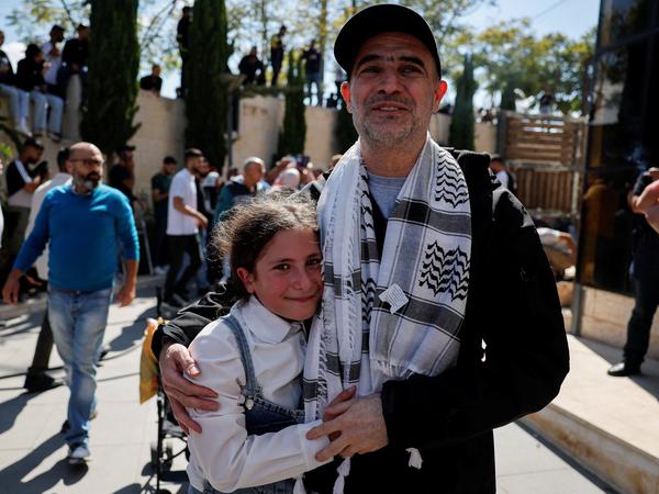A freed Palestinian prisoner embraces his daughter after he was released from an Israeli jail as part of a hostages-prisoners swap and a ceasefire deal in Gaza between Hamas and Israel, in Ramallah, in the Israeli-occupied West Bank, October 13, 2025. REUTERS/Ammar Awad