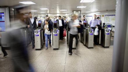 Fahrgäste betreten die Londoner U-Bahn durch Sicherheitskontrollen.