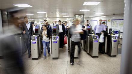 Fahrgäste betreten die Londoner U-Bahn durch Sicherheitskontrollen.