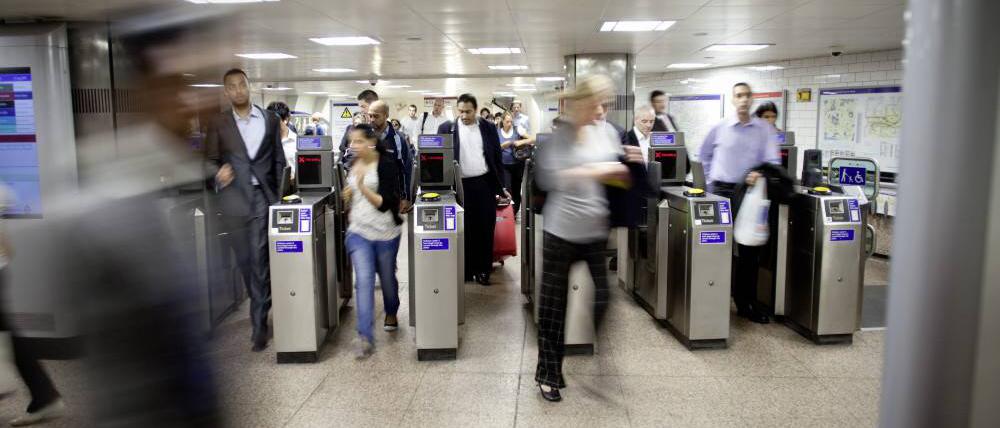 Fahrgäste betreten die Londoner U-Bahn durch Sicherheitskontrollen.