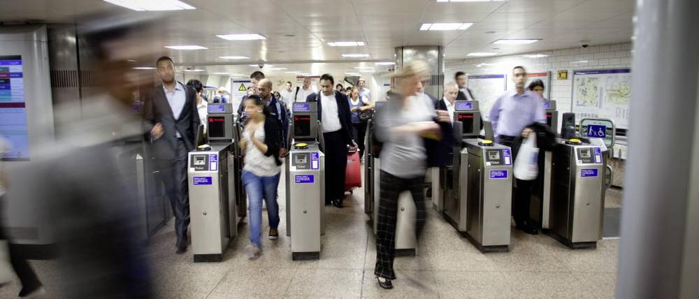 Fahrgäste betreten die Londoner U-Bahn durch Sicherheitskontrollen.