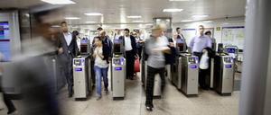 Fahrgäste betreten die Londoner U-Bahn durch Sicherheitskontrollen.