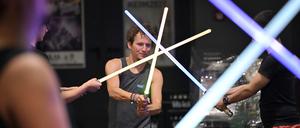 Mehrere Teilnehmer eines Lichtschwertkampfes schwingen ihre Schwerter. (Archivbild)