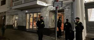 Polizisten sichern die Kontrolle in der Roma-Unterkunft im ehemaligen Hotel ab.