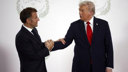 Macron und Trump schütteln Hände.