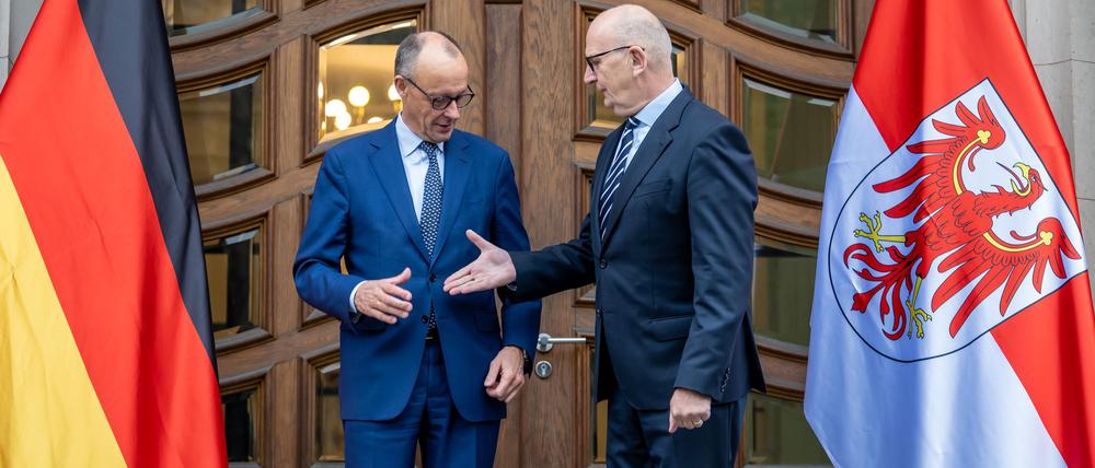„Shake hands“ zum Auftakt: Kanzler Merz (CDU) wird vom brandenburgischen Ministerpräsidenten Dietmar Woidke (SPD) empfangen. Es ist der erste offizielle Antrittsbesuch des Kanzlers in einem ostdeutschen Bundesland.