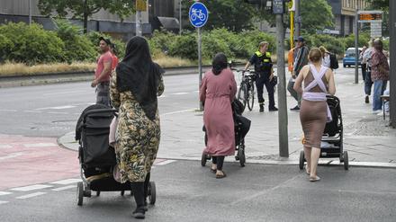 Menschen gehen über eine Fußgängerampel (Symbolbild).