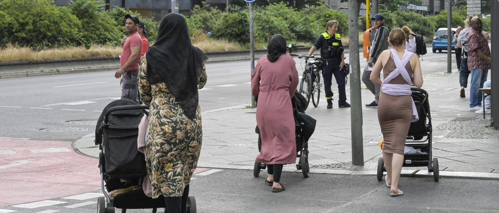 Menschen gehen über eine Fußgängerampel (Symbolbild).