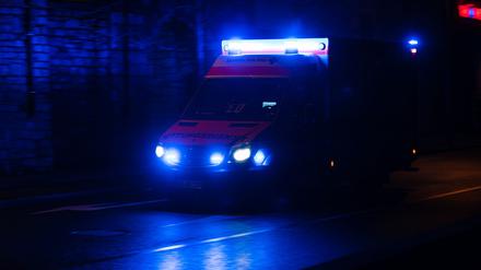 Ein Krankenwagen fährt nachts mit Blaulicht durch eine Straße. (Symbolbild)