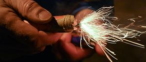 Ein Mann zündet einen Böller am Silvesterabend an. +++ dpa-Bildfunk +++