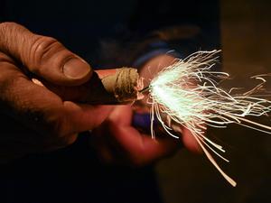 Ein Mann zündet einen Böller am Silvesterabend an.