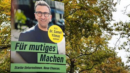 Ein Wahlplakat des Grünen-Bürgermeister-Kandidaten Samet Yilmaz hängt an einem Laternenmast in Kiel.