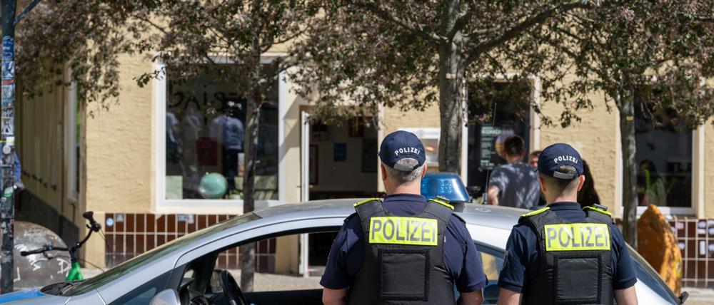 Polizeibeamte stehen vor dem Cafe «Bajszel» in der Emser Straße in Neukölln.