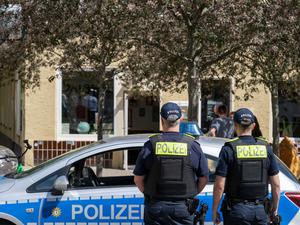 Polizeibeamte stehen vor dem Cafe «Bajszel» in der Emser Straße in Neukölln. 