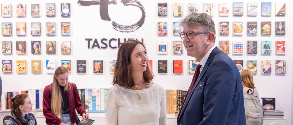 Kulturstaatsminister Wolfram Weimer am Ausstellungsstand vom Taschen Verlag im Gespräch mit der Verlegerin Marlene Taschen.