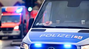 Ein Polizeiauto und ein Rettungswagen mit Blaulicht.