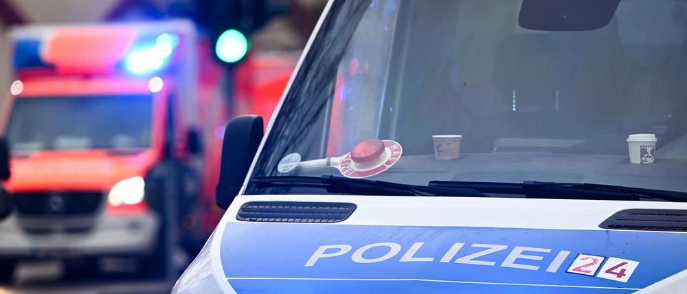 Ein Polizeiauto und ein Rettungswagen mit Blaulicht.