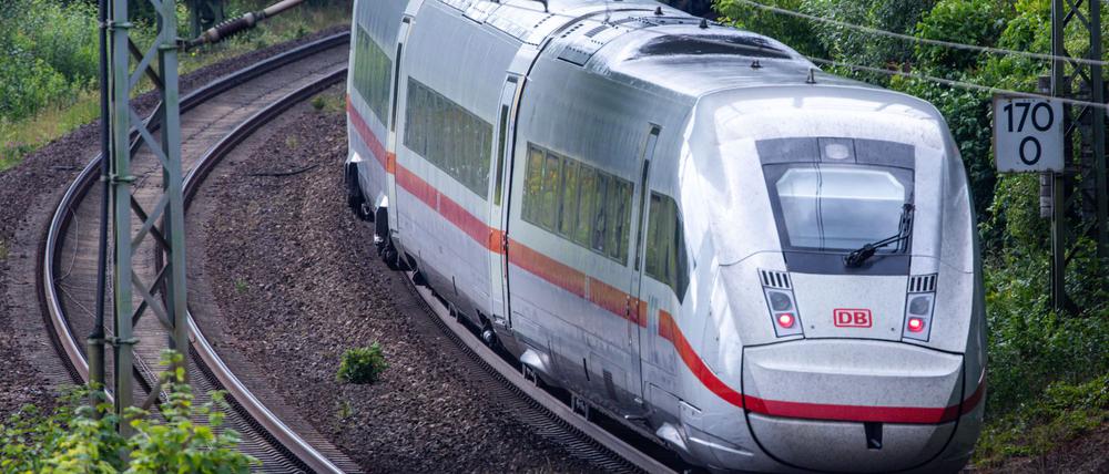 Ein ICE-Zug fährt zwischen Berlin und Hamburg auf den Gleisen in der Nähe eines Bahnhofs.