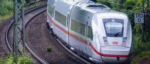 Ein ICE-Zug fährt zwischen Berlin und Hamburg auf den Gleisen in der Nähe eines Bahnhofs.