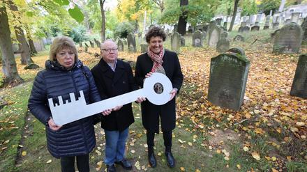 Brigitte Meier (rechts) übergibt die Erweiterung für den Friedhof an Gennadi Kuschnir und Elena Miropolskaja vom Landesverband der jüdischen Gemeinden.