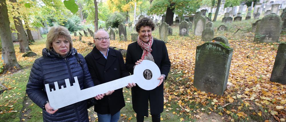 Brigitte Meier (rechts) übergibt die Erweiterung für den Friedhof an Gennadi Kuschnir und Elena Miropolskaja vom Landesverband der jüdischen Gemeinden.